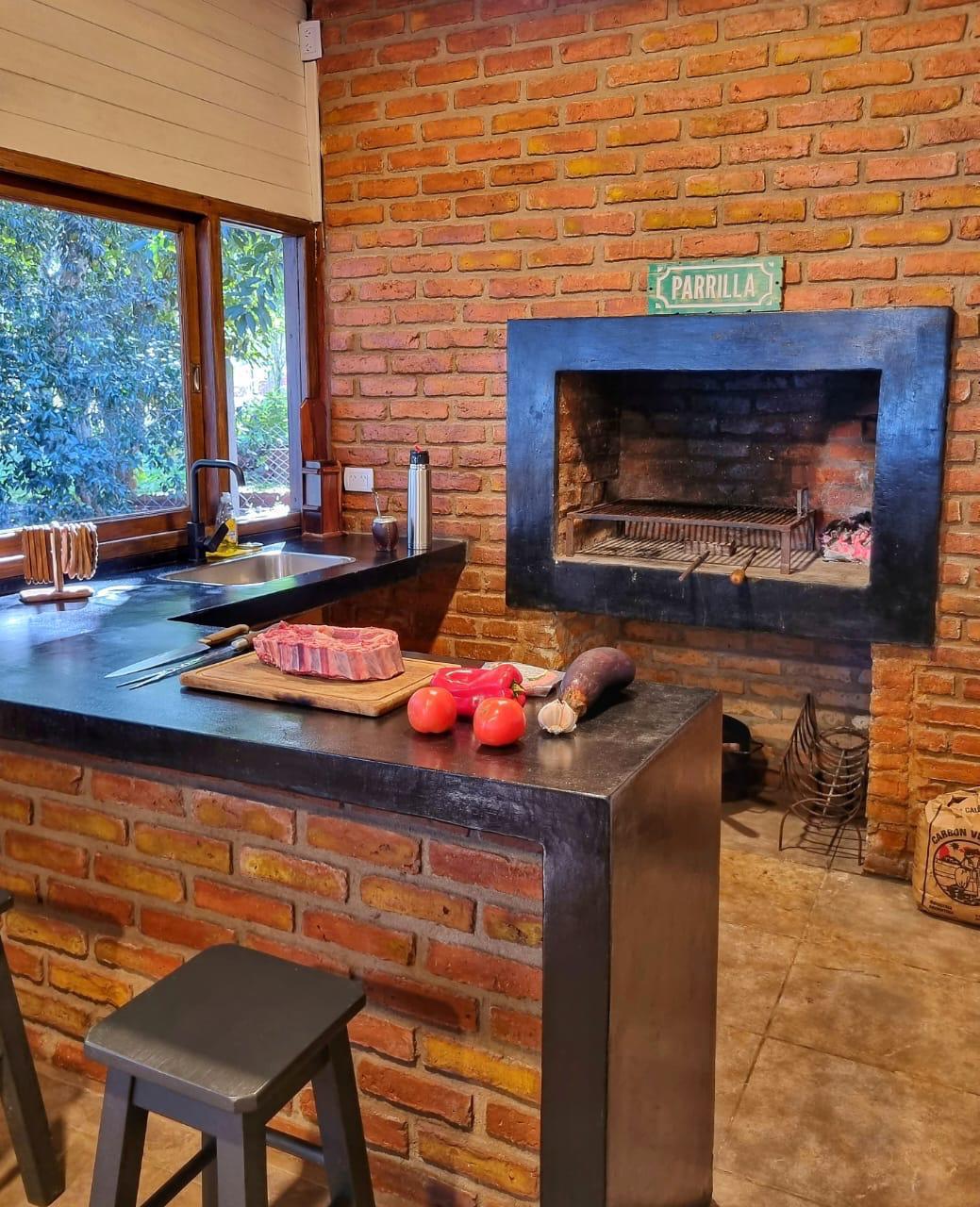 La parrilla encendida y las verduras sobre la mesada