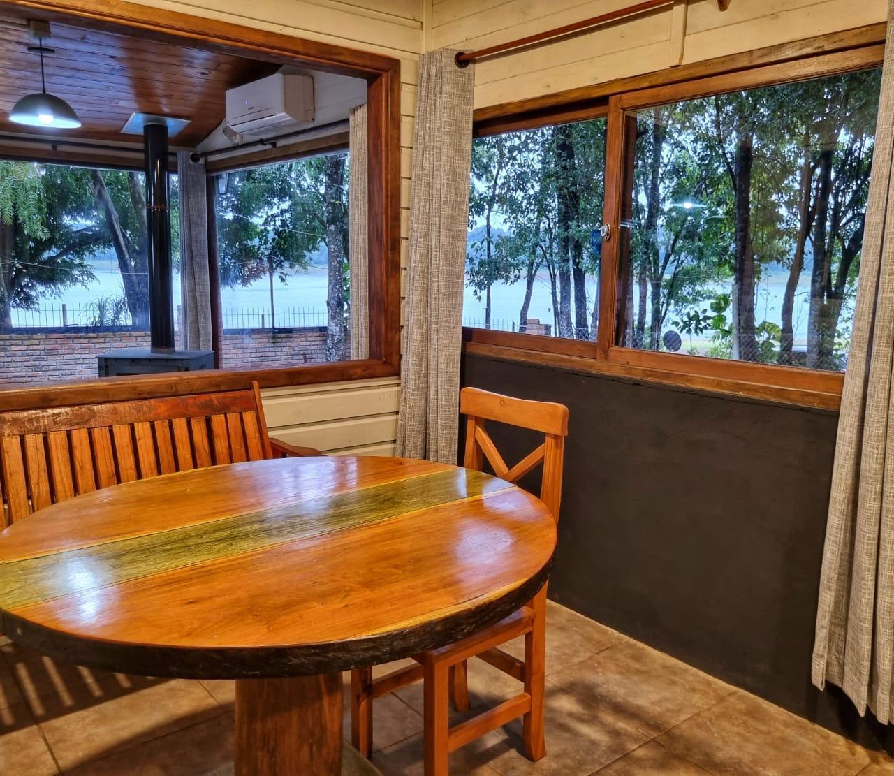 El comedor con los ventanales abiertos al lago