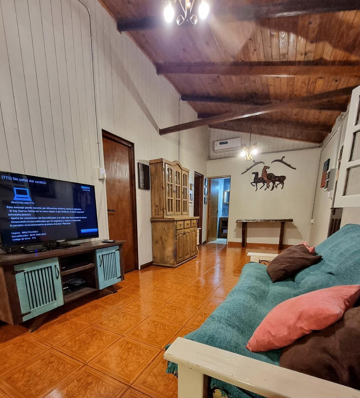 Living con Smart TV y sofá con almohadones